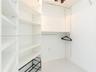 Custom closet organization system featuring adjustable white shelving, hanging rods, and an integrated tiered shoe rack