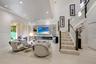 Living area featuring recessed lighting, a built-in linear fireplace with surround shelving, tile-finish flooring, and a staircase with glass railings