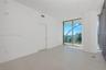Interior space featuring large-format ceramic tile flooring, a prominent architectural cylindrical column, floor-to-ceiling glass sliding doors, and a