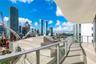 Curved exterior balcony featuring large-format tile flooring and glass panel railings