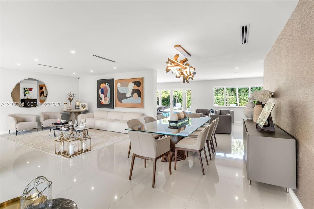 Large-format white tile flooring, modern geometric chandelier, textured feature wall, and multi-panel glass garden doors