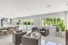 Open-concept interior featuring large-format tile flooring, recessed lighting, and a kitchen island with quartz-style countertop