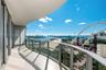 Curved, expansive balcony featuring large-format tile flooring and a glass-paneled railing