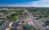 Aerial perspective of a corner lot featuring direct road frontage, prominent street visibility, and existing building structures