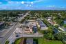Aerial perspective of a corner lot property featuring frontage along a primary roadway, surface parking, and a single-story commercial structure