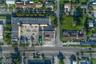 Corner lot featuring paved surface area, rectangular footprint, and direct exposure to primary roadway