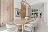 Dining space featuring wood-paneled accent walls, integrated wall-mounted lighting, a multi-pendant glass chandelier, and soaring arched architectural