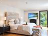 Recessed lighting, wood-finish flooring, and a glass-paneled door with dark trim framing exterior foliage