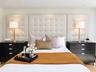 Full-height upholstered tufted headboard featuring integrated recessed ceiling lighting