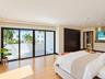 Interior space featuring wood-finish flooring, recessed lighting, floor-to-ceiling sliding glass doors, a built-in recessed media niche, and dark wood