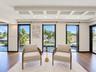 Coffered ceiling with recessed lighting, wood-finish flooring, and floor-to-ceiling windows featuring water frontage