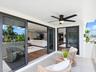 Covered balcony featuring oversized porcelain tile flooring, black-framed sliding glass doors, and an integrated LED ceiling fan