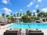 Waterfront swimming pool with a paved patio, metal safety fencing, and private boat dockage