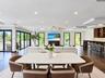 Open-concept interior featuring recessed lighting, dark wood-finish flooring, multi-panel sliding glass doors, and a built-in wet bar with cabinetry