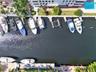 Deep-water canal frontage featuring multiple concrete bulkhead docks, boat slips, and a swimming pool