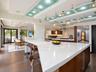 Kitchen featuring an oversized island with a solid surface countertop, wood-finish cabinetry, stainless steel range hood, recessed ceiling lighting wi