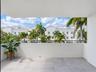 Covered balcony featuring large-format stone-finish floor tiles and a black metal railing