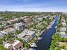Aerial perspective of a waterfront residential district featuring private boat slips, deep-water canal access, multi-story masonry structures, and lus