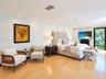 Light-filled bedroom featuring wood-finish flooring, recessed lighting, and a glass-paneled door