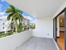 Covered balcony featuring oversized gray tile flooring, a metal railing, and sliding glass door access