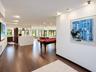 Open-concept space featuring wood-finish flooring, recessed lighting, and a kitchen island with a stone-surfaced countertop