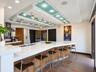 Kitchen featuring a custom tiered drop ceiling with integrated glass panels, recessed lighting, and adjustable track lighting, paired with an expansiv