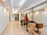 Hallway featuring tile flooring, recessed ceiling lighting, a tray ceiling detail, and floor-to-ceiling wall mirrors