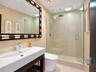 Bathroom featuring a wall-mounted vanity with integrated sink, walk-in glass-enclosed shower with rain-style showerhead, and recessed lighting