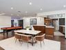Open-concept interior featuring wood-finish flooring, recessed lighting, and a kitchen equipped with flat-panel wood cabinetry, stone countertops, and
