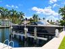 Deep-water canal frontage featuring a boat lift, concrete dockage, and a swim ladder