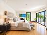 Room featuring wood-finish flooring, recessed lighting, and expansive floor-to-ceiling multi-panel sliding glass doors leading to an exterior balcony