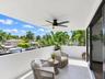 Covered balcony featuring large-format tile flooring, metal railings, and a ceiling-mounted matte black fan