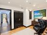 Interior space featuring wood-finish flooring, recessed ceiling lighting, and contrasting dark-finished door trim