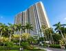 Aerial coastal perspective featuring high-rise towers, private marina slips, and proximity to the open ocean