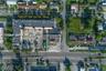 Aerial perspective of the subject property featuring a paved parking area, commercial structure, and street frontage