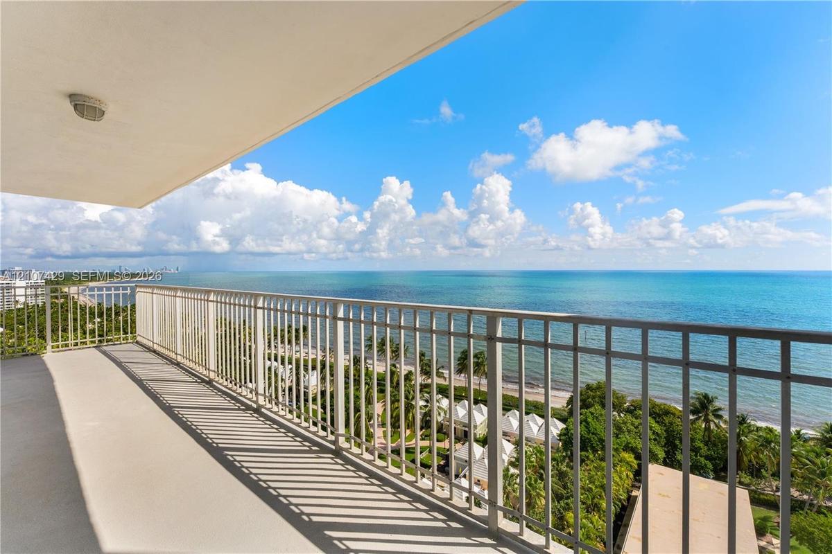 Covered balcony featuring a metal railing, concrete flooring, and an overhead flush-mount light fixture