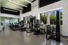 Fitness center featuring high ceilings, linear pendant lighting, large windows, and resilient flooring