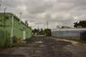 Paved exterior lot featuring metal-sided structures and chain-link fencing