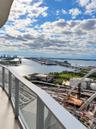 Private balcony with glass panel railing and panoramic waterfront and city skyline scenery