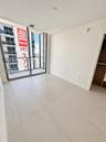 Floor-to-ceiling glass paneling with integrated sliding door access to a private balcony, large-format tile flooring, and a built-in closet system