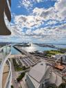 Curved private balcony featuring glass railings and panoramic water and city skyline outlooks