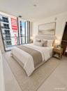 Floor-to-ceiling glass windows, neutral-toned large format tile flooring, and a walk-in closet with built-in shelving
