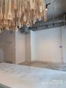 Industrial-style interior featuring exposed concrete ceilings, polished concrete flooring, track lighting, and a kitchen island with a white speckled 