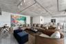 Industrial-inspired kitchen featuring an exposed concrete ceiling with surface-mounted conduit, high-gloss white cabinetry, stainless steel appliances