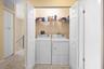 Laundry closet featuring dual-folding doors, wire shelving