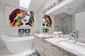 Skylight, freestanding soaking tub, double-sink vanity with stone countertop, walk-in glass-enclosed shower, and recessed ceiling lighting