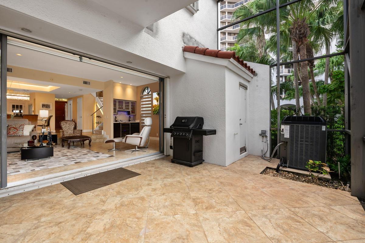 Screened-in patio featuring tile flooring, a terracotta-tiled roof accent, and retractable glass doors