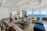 Floor-to-ceiling windows, exposed concrete ceiling, industrial-style drum pendant lighting, polished stone-finish flooring, and exposed concrete struc