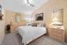 Vaulted ceilings, neutral wall tones, multi-level ceiling fan with integrated lighting, and dual-layer window treatments