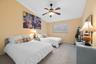 Vaulted ceiling, wall-to-wall carpeting, ceiling fan with integrated lighting, and horizontal window blinds